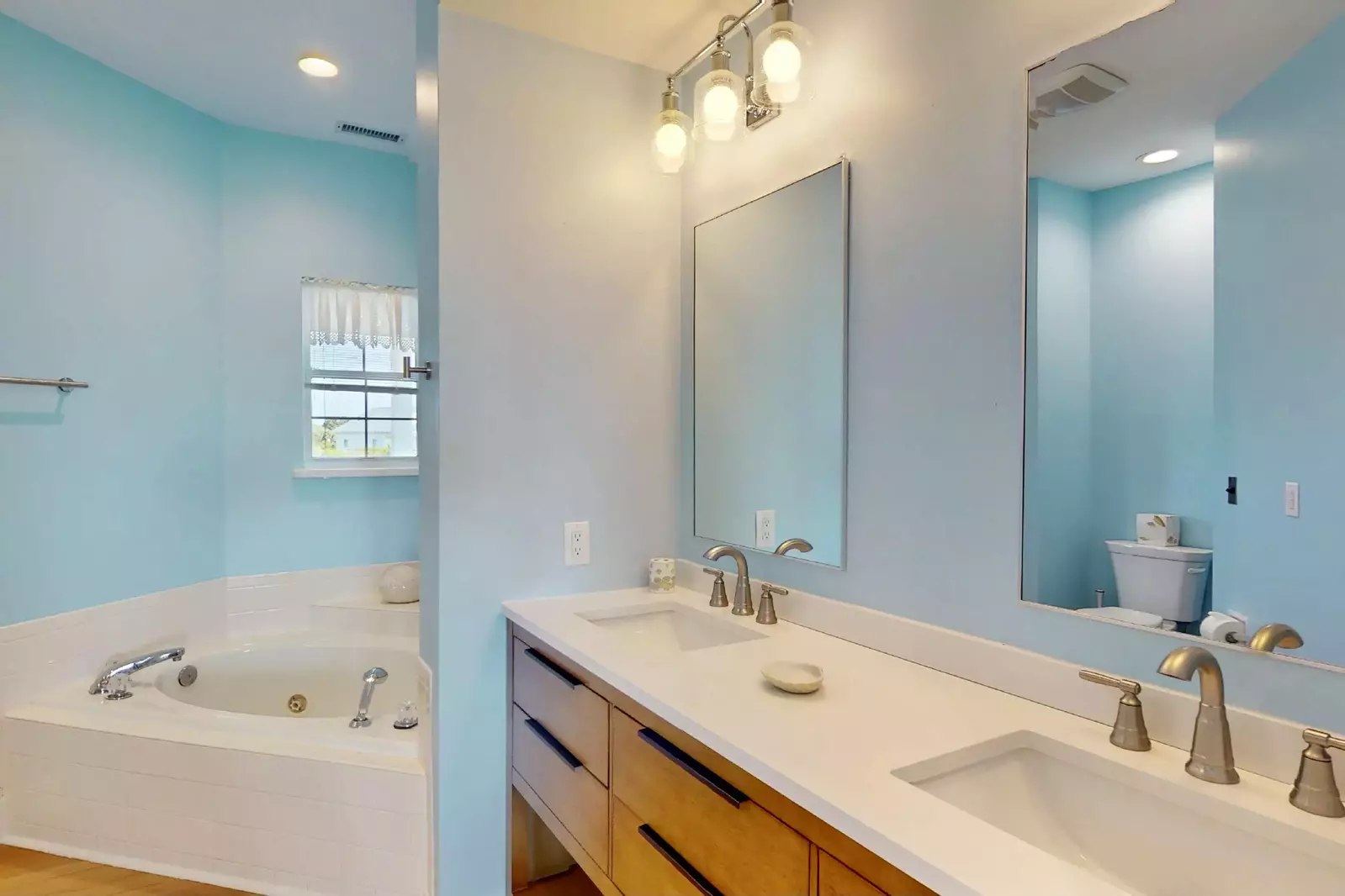 The primary en-suite bathroom features a double vanity and a jetted tub