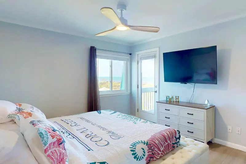 The owner's suite features a king bed, flat screen tv and direct access to the deck