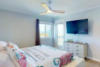 The owner's suite features a king bed, flat screen tv and direct access to the deck