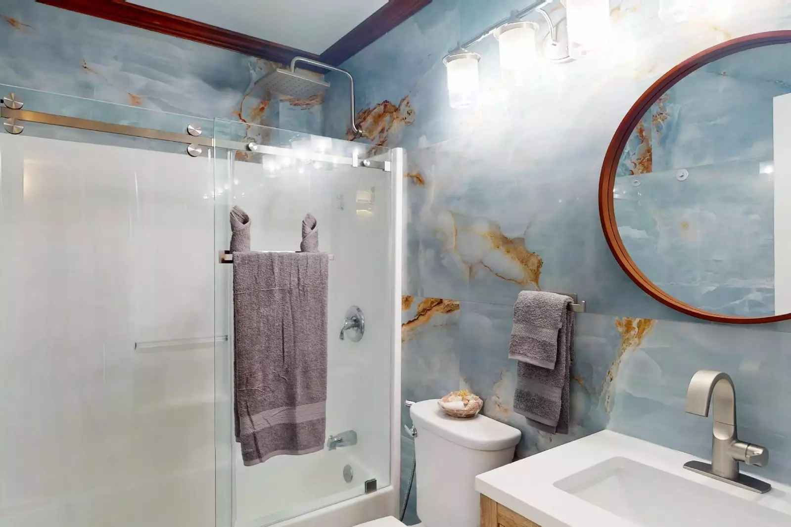 The hall bathroom has beautiful marble walls and a tub/shower combo