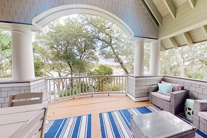 The upstairs covered deck offers plenty of seating and views of the marsh