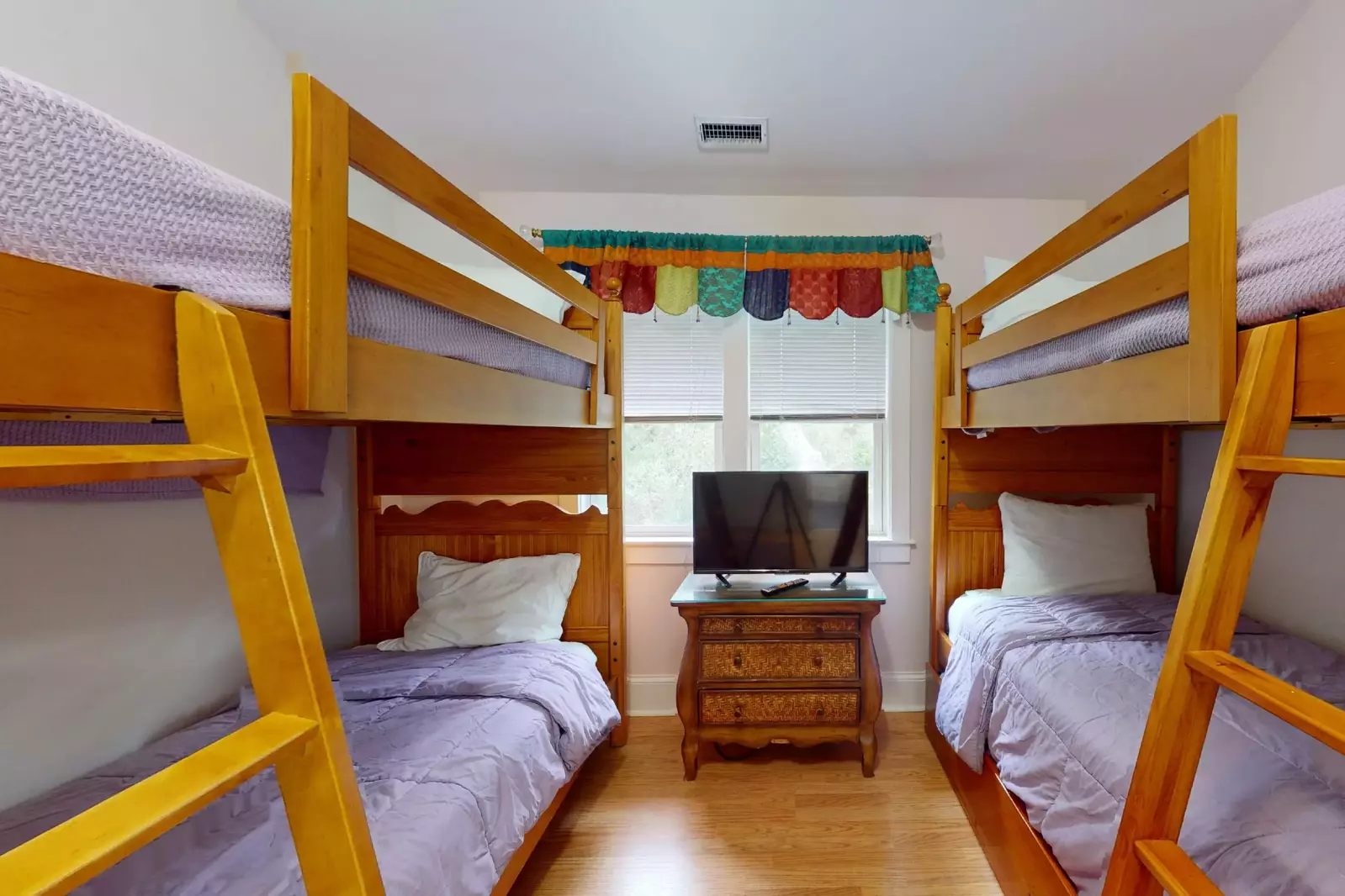 The bunk room has two sets of twin bunk beds and a flat screen tv