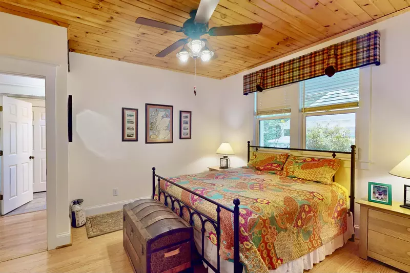 The downstairs queen bedroom has a wood ceiling and a full bathroom across the hall