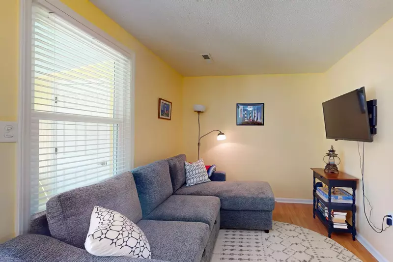 The living room features a couch with a chaise lounge and flat screen tv. The couch also folds out into a bed.