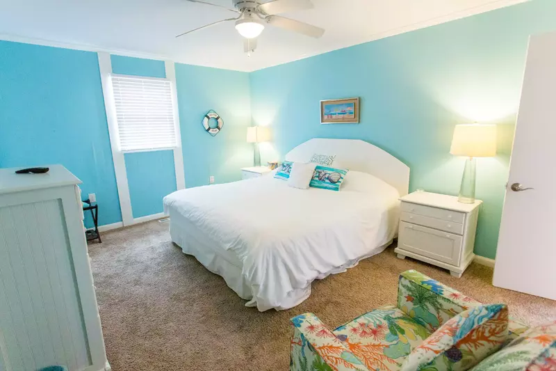 Second bedroom features a king bed, sitting chair and tv