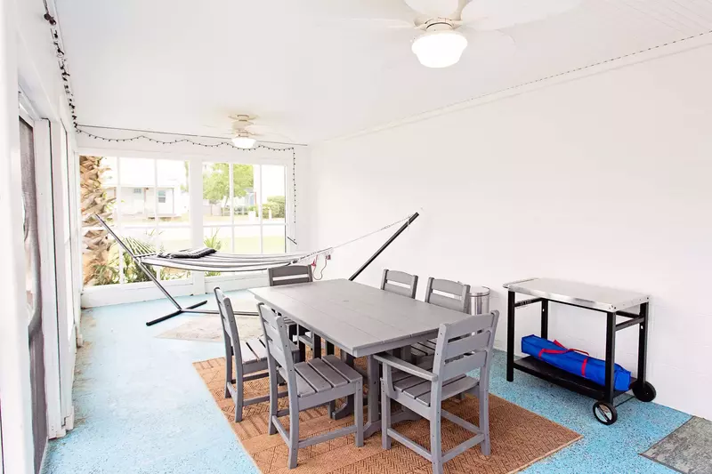 The large screened porch has a second dining table and a hammock for maximum relaxation