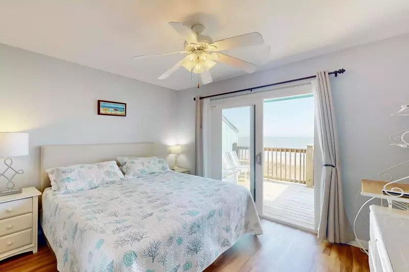 Bright master bedroom with a king bed overlooking the ocean