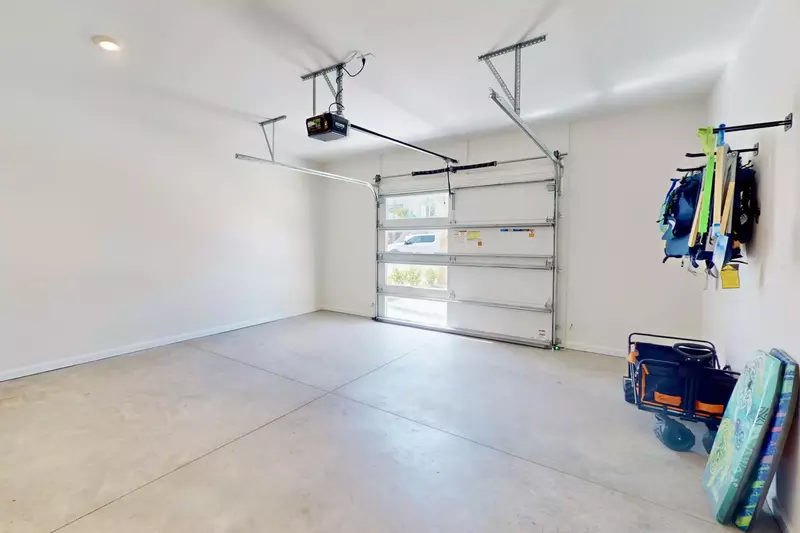 Garage features EV charging station, a beach wagon, chairs and toys