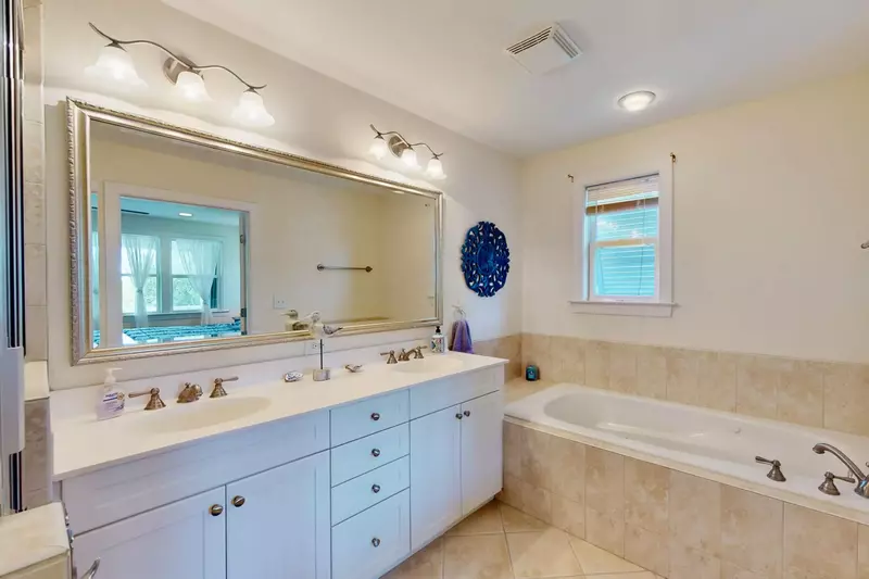 The owners suite bathroom boasts a double sink, jacuzzi tub, and a walk in shower