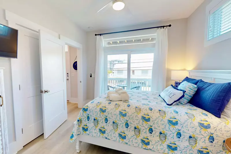 Queen bedroom with balcony and wall mounted tv