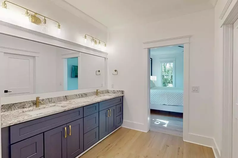 The main owner suite has a huge bathroom with a large mirror and 2 sinks