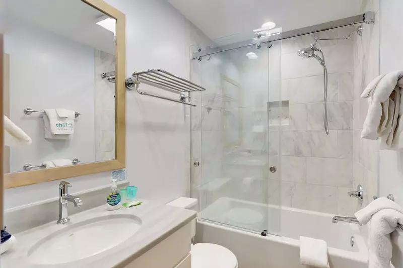 Full hallway bathroom with a lovely glass enclosed tub/shower combo