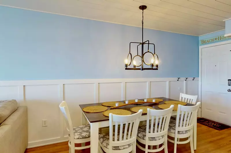 Enjoy your meals at the dining table with modern lighting and a chair rail