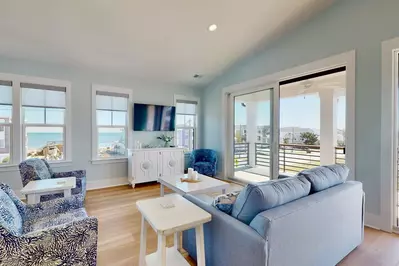 The bright, spacious living room has plenty of space for the entire group with the ocean just out the window!