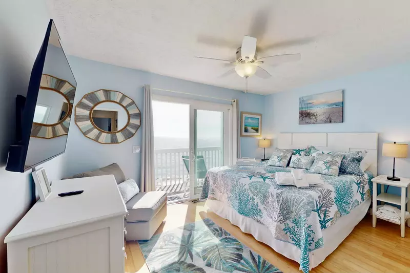 The primary bedroom has a king bed, smart TV, and spectacular ocean views