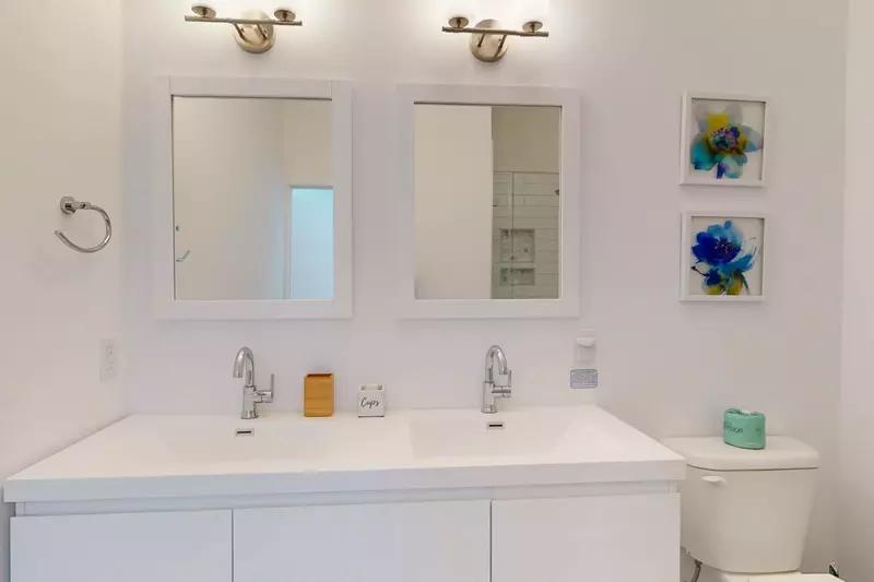 Dual sinks and a tiled shower are featured in the ensuite bathroom