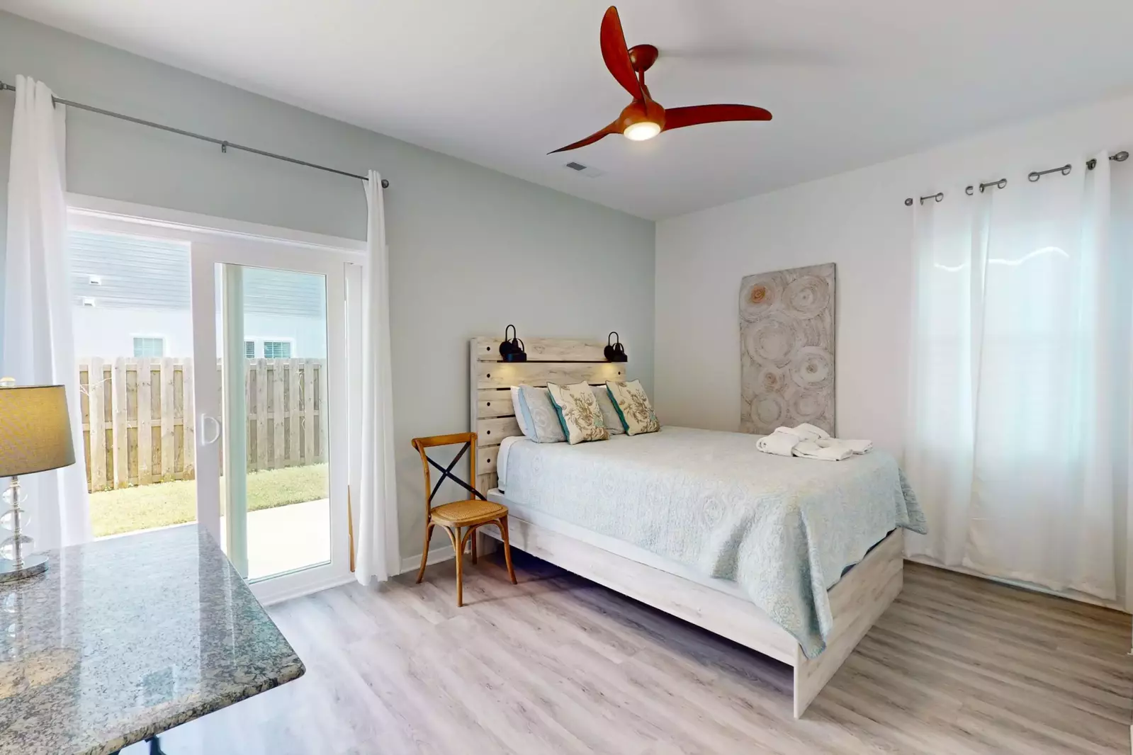 Bedroom #2 boasts a queen bed and sliding glass door to the backyard