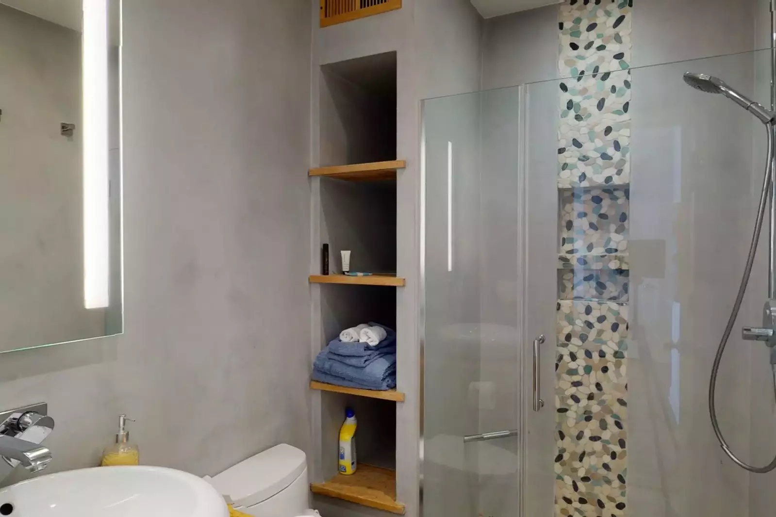 Second bathroom features a walk in shower with intricate European style tile work and built-ins