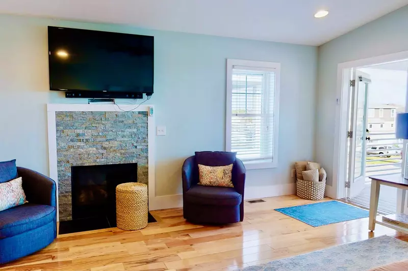 Living room features a large screen tv and fireplace
