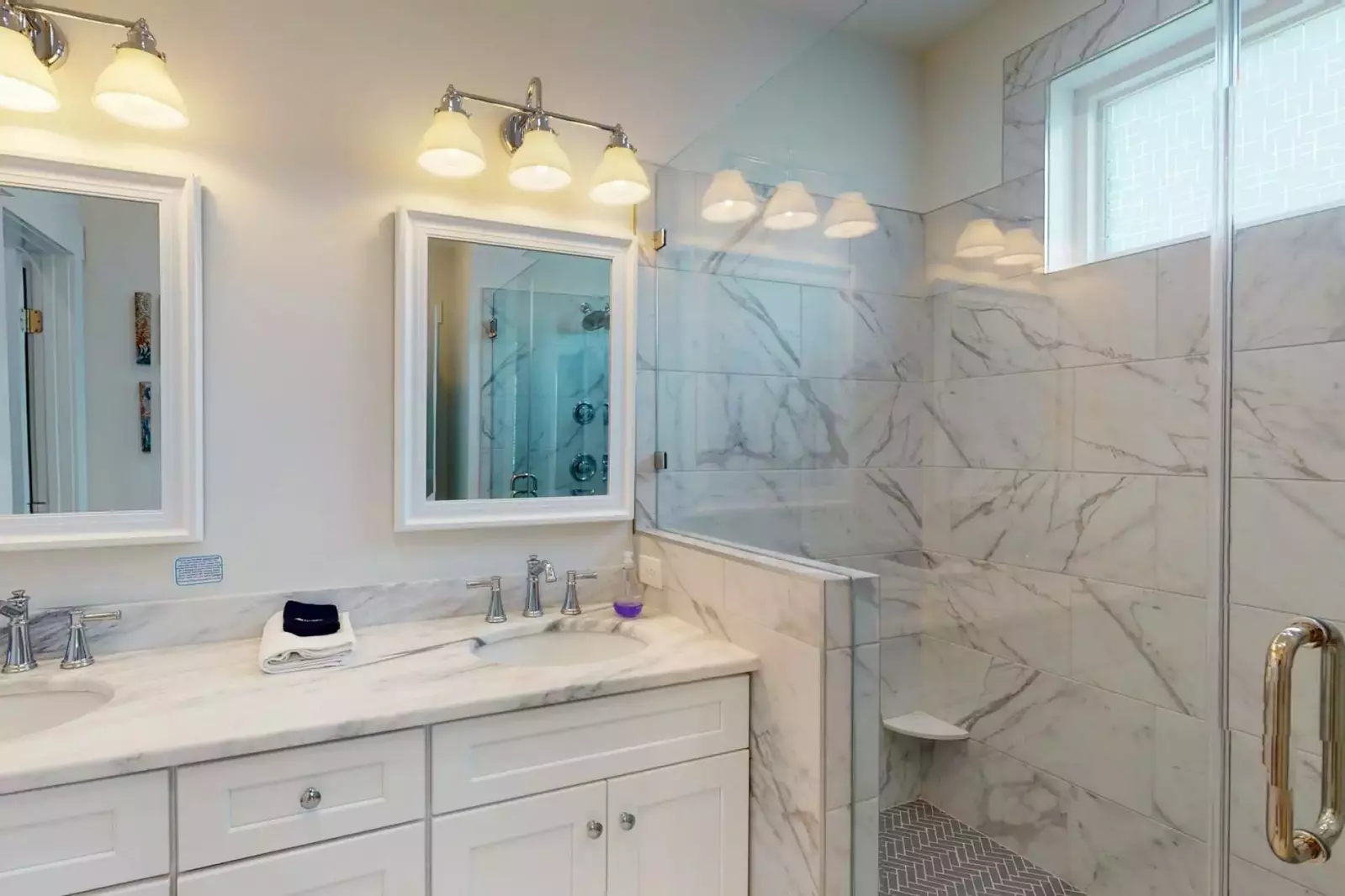 1st floor king suite bathroom with double vanity sinks and a large walk in shower, with a separated area for the toilet