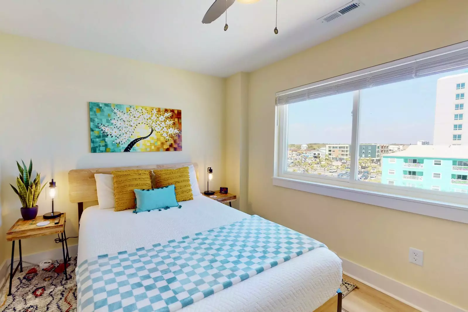 The second bedroom has a queen bed and a large window overlooking Carolina Beach