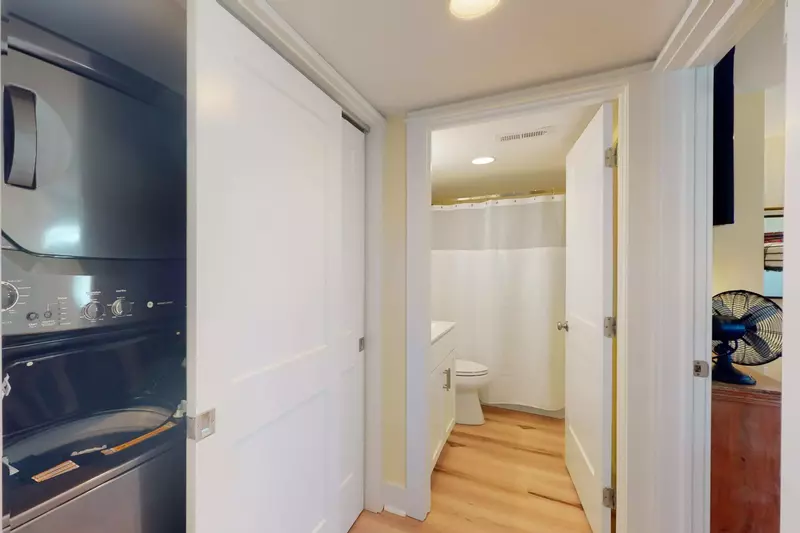 The in-unit washer and dryer are located just outside the hallway bathroom