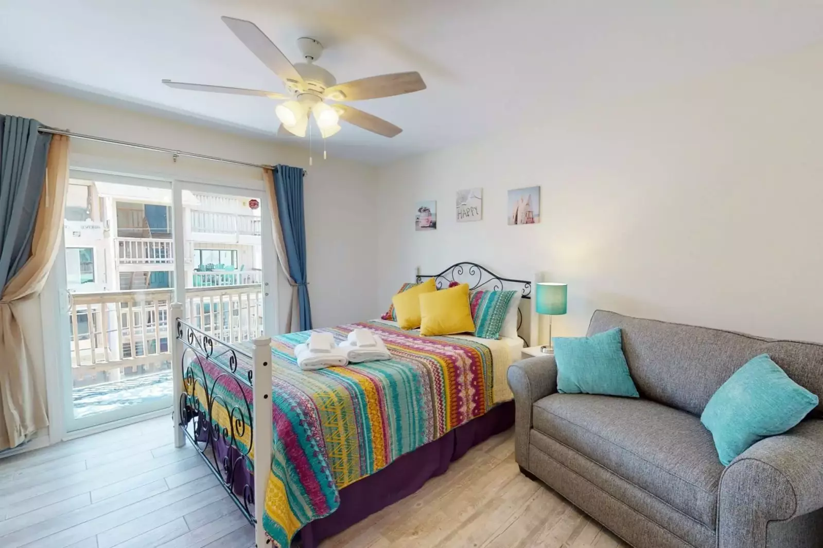 Third bedroom with comfy seating and sliding glass doors to back balcony