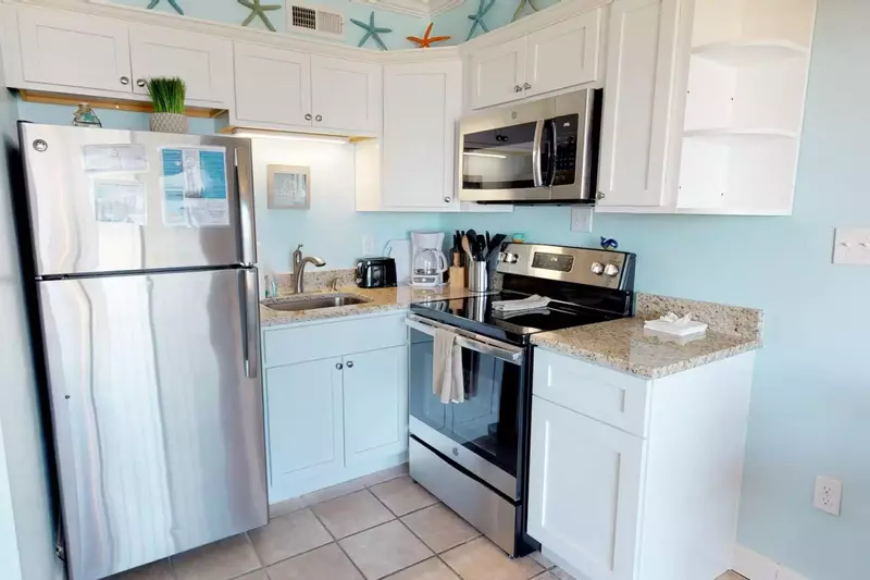 A well equipped kitchen with a full size fridge, microwave, oven, stovetop, coffee maker, and many cooking tools to make your own meals.