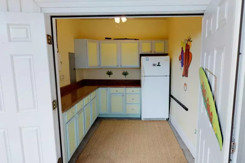 The outdoor kitchen has a fridge and a prep area.