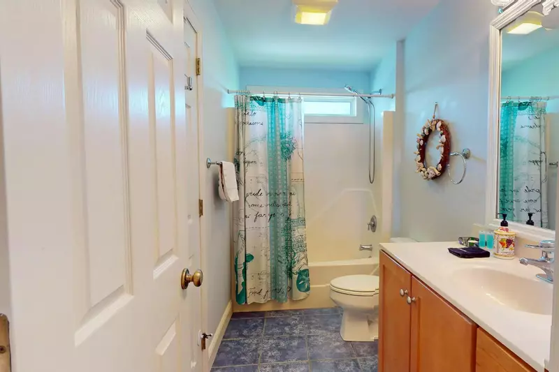 One of the full baths upstairs has a beachy feel and is stocked with high quality new towels