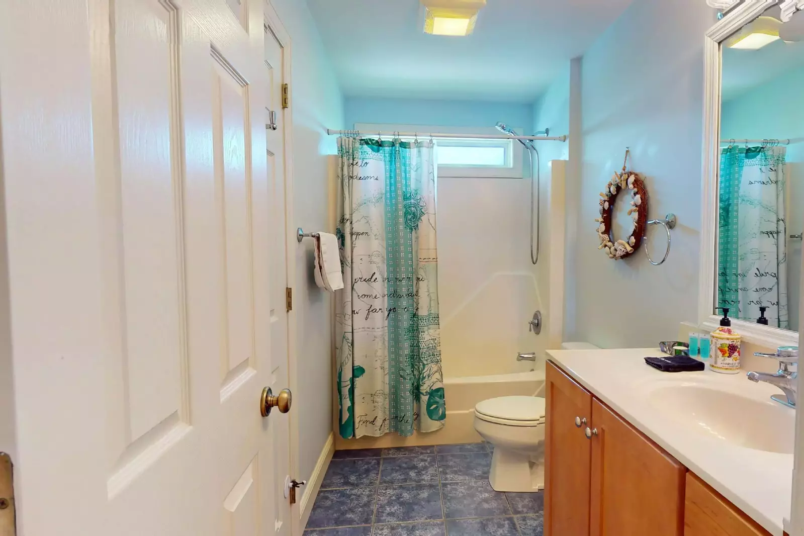 One of the full baths upstairs has a beachy feel and is stocked with high quality new towels