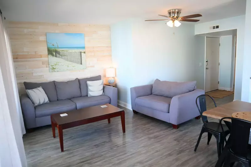 Relax in the comfy, spacious living room with a custom wood wall after a long day at the beach.