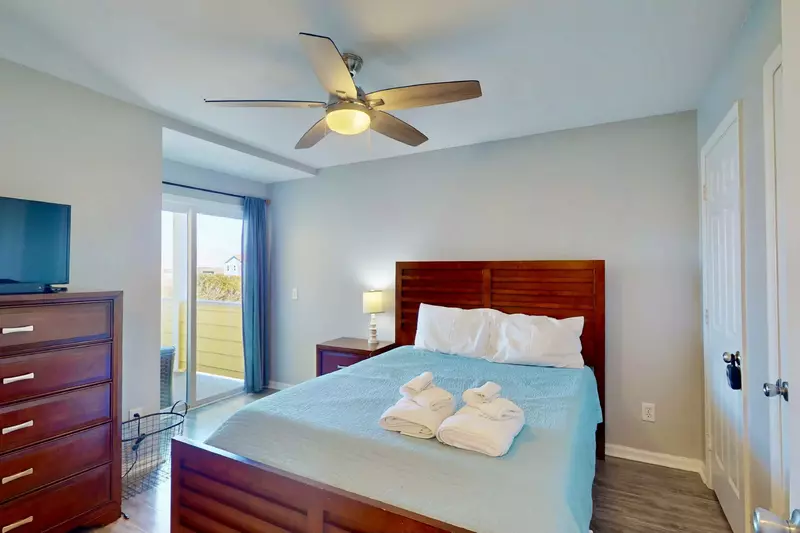 The guest bedroom features a queen bed and has access to the back deck.