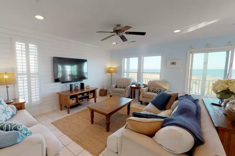 The living room includes a big screen TV to watch that important game with plenty of comfy places to sit and enjoy a movie as well