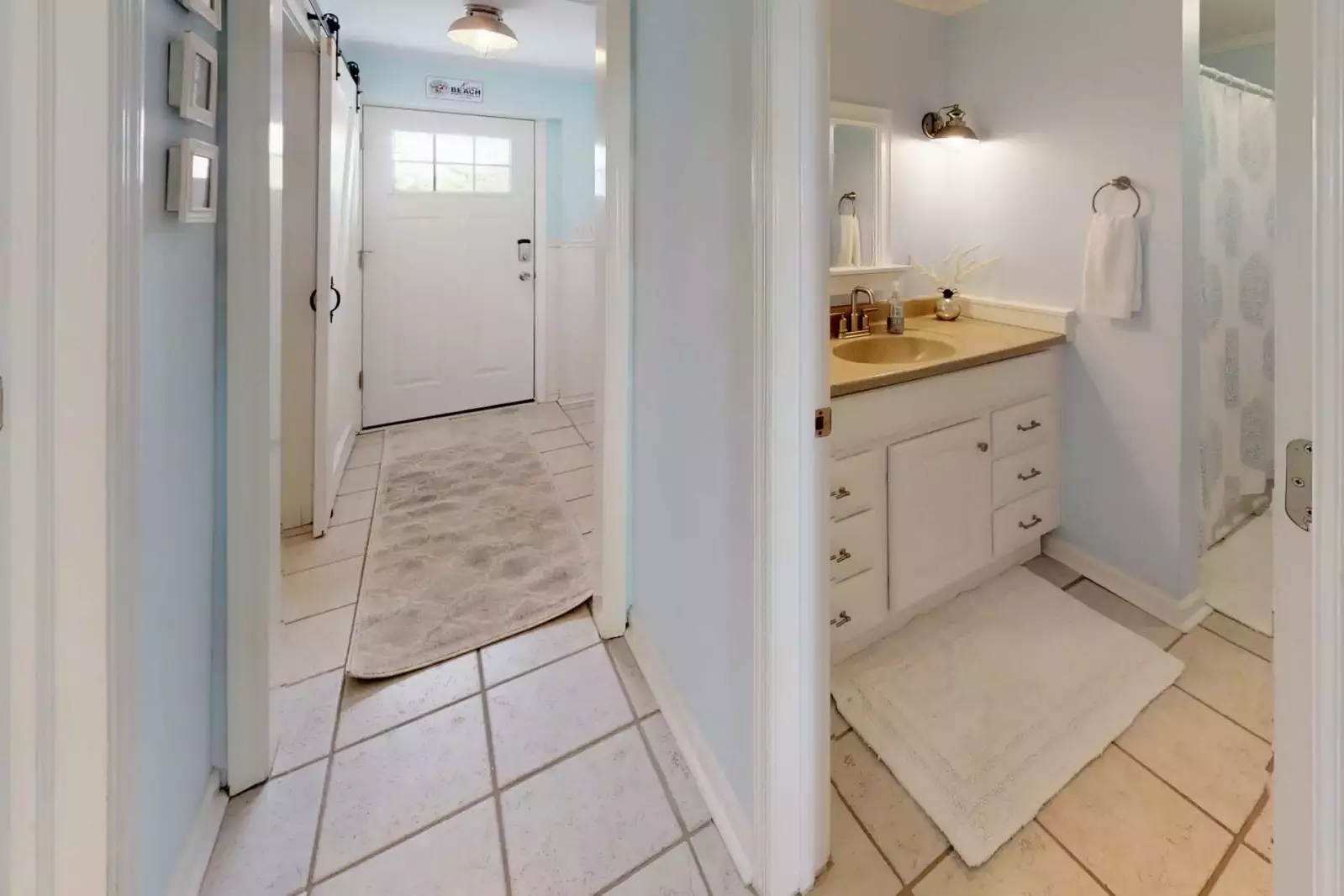 Entrance hallway into the house and view of the full bathroom on the bottom floor