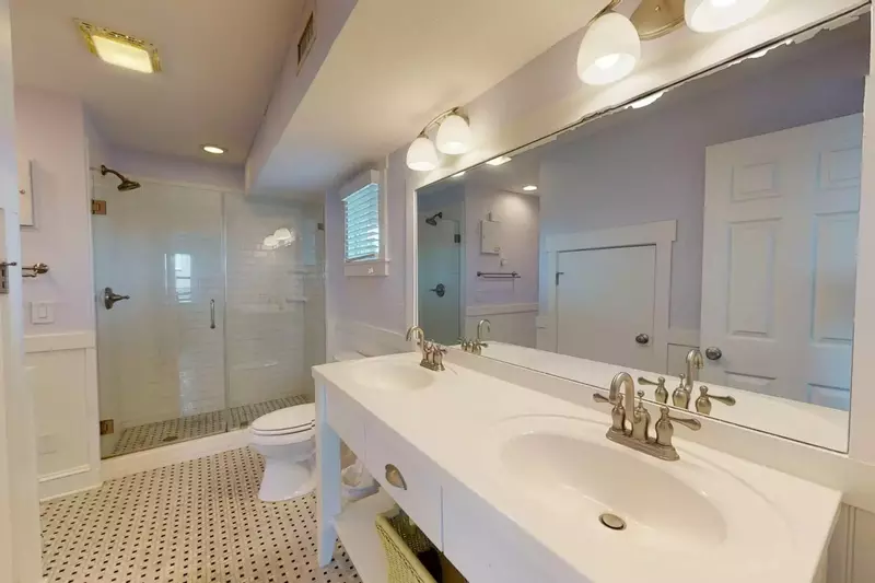 Master bath with an updated large glass tiled shower