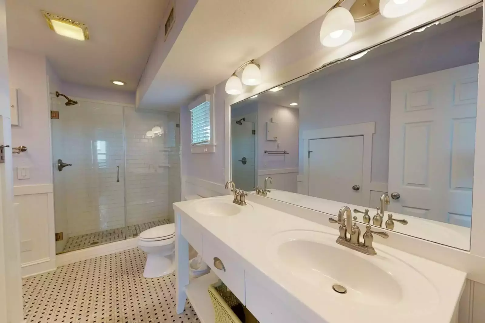 Master bath with an updated large glass tiled shower