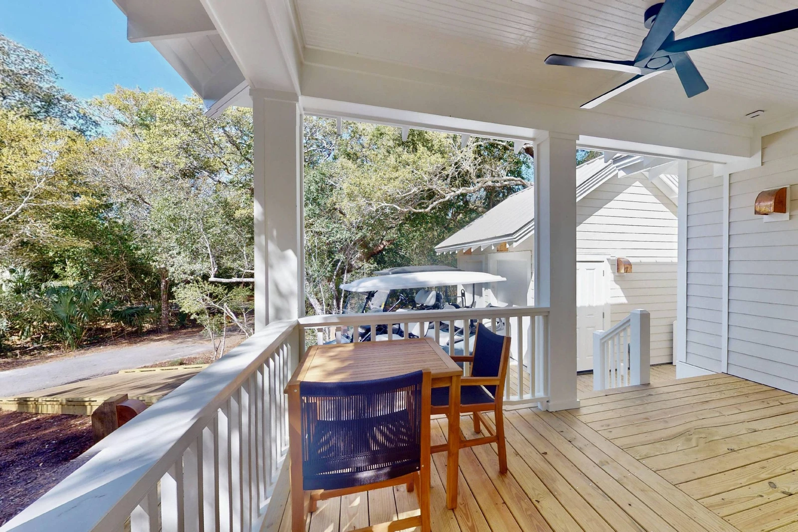 The front patio offers a small table and seating