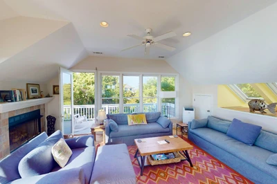 The living room opens to a second top floor deck with seating
