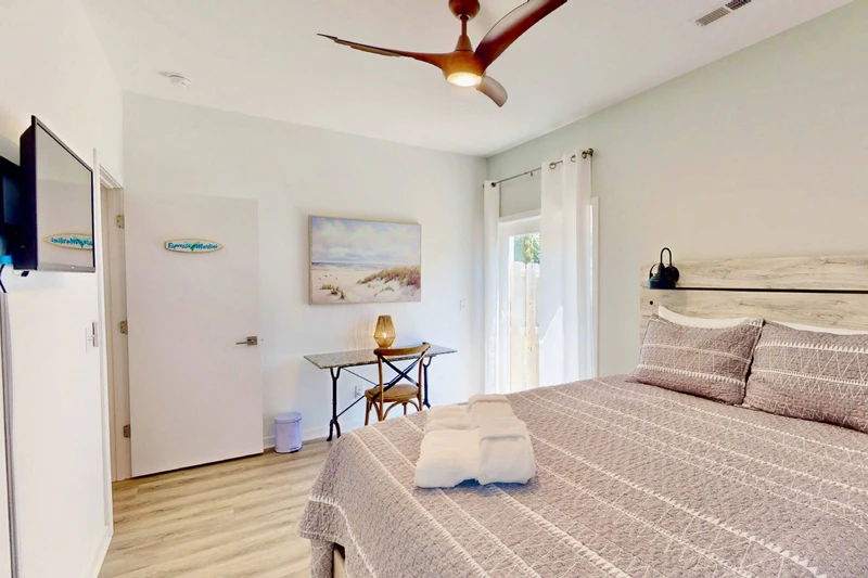 Bedroom 2 boasts a queen bed, desk and sliding glass door to the backyard