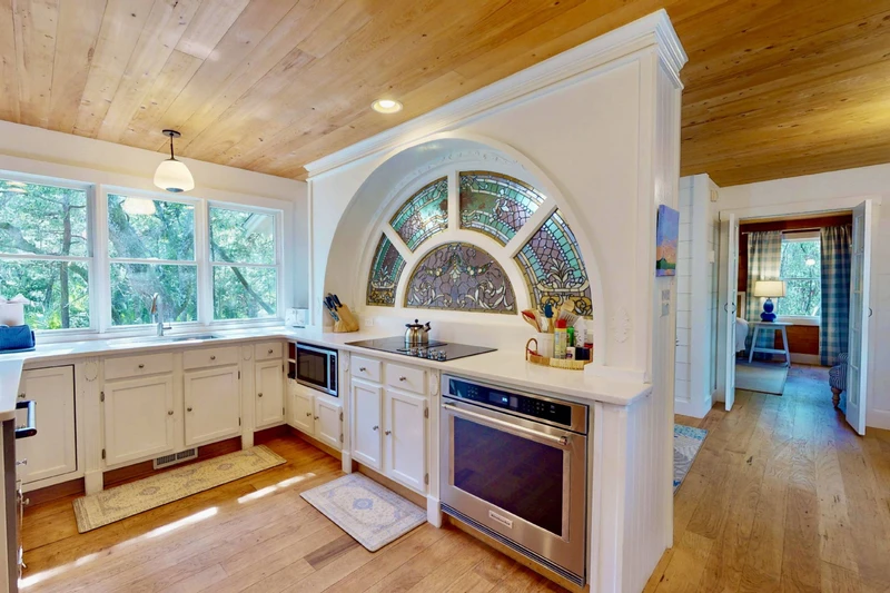 The kitchen features a lovely custom stained glass window