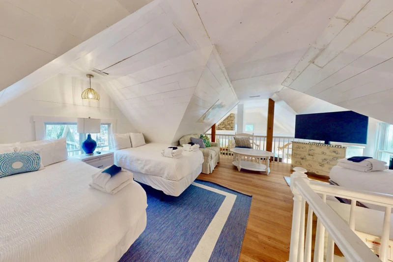 Upstairs loft with two double beds and a twin bed