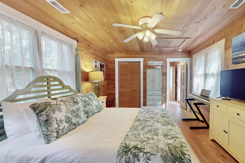The first queen bedroom in the guest wing offers a queen bed, private porch, tv and keyboard.
