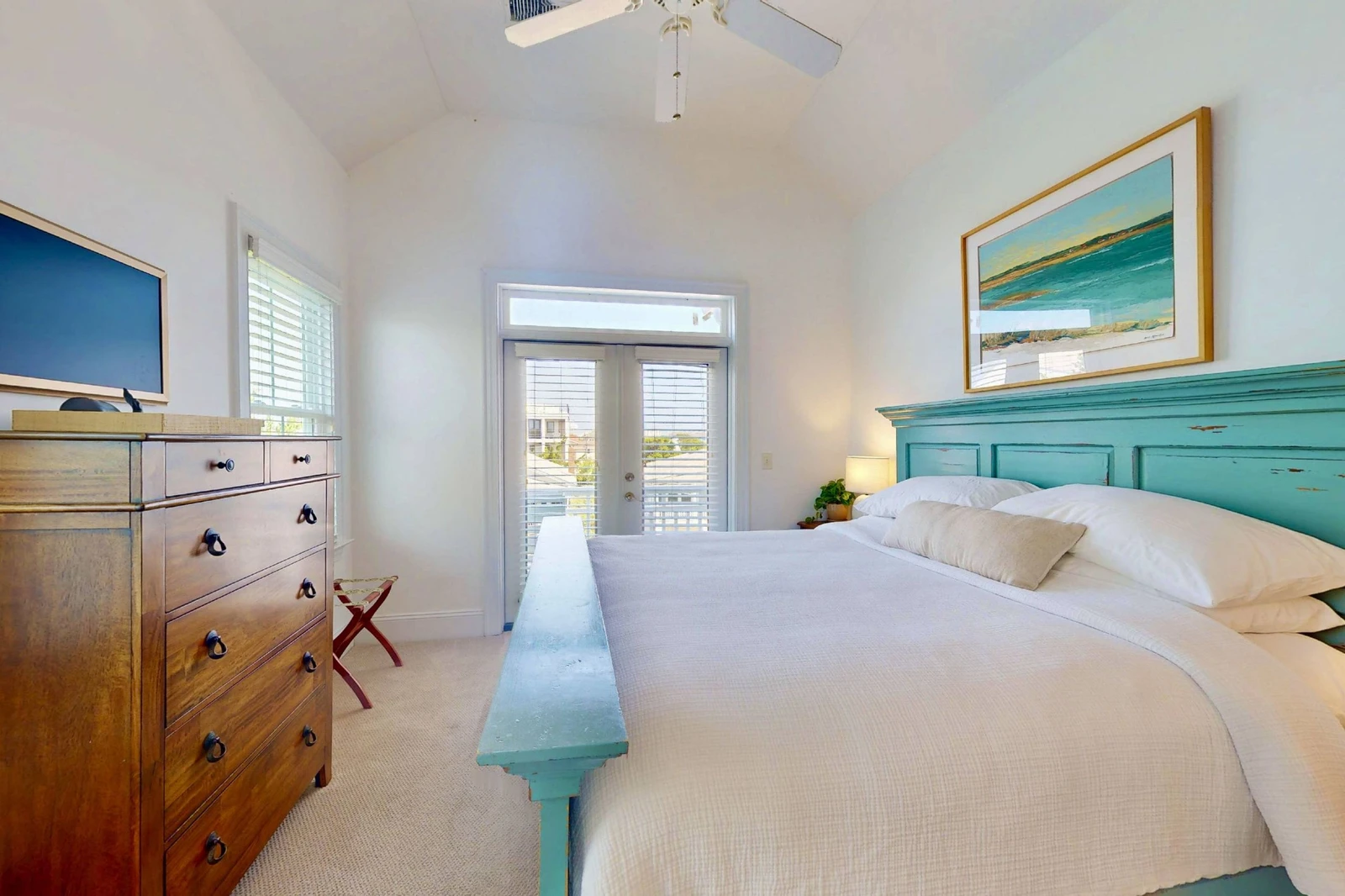 Bedroom 4 has a wall mounted tv and direct access to a top floor deck with peekaboo water views