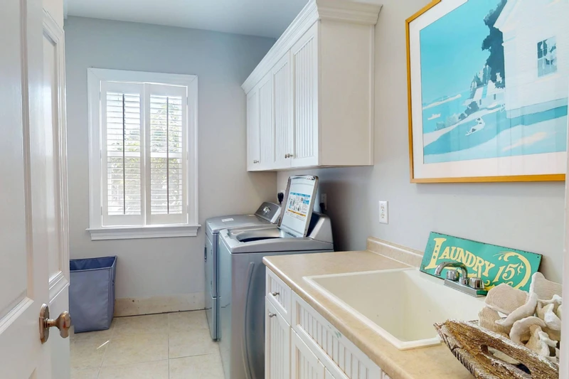 A laundry room features a full size washer & dryer plus a sink