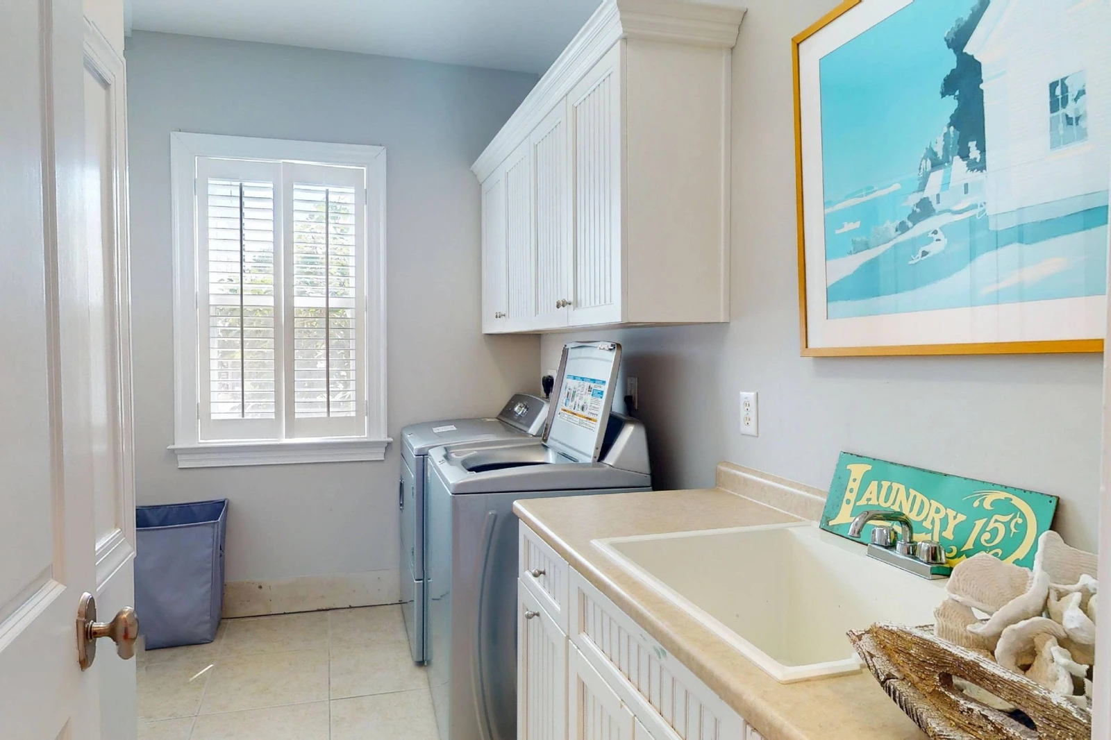 A laundry room features a full size washer & dryer plus a sink